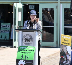 Lisa Lee of EZ Ride gestures at podium.